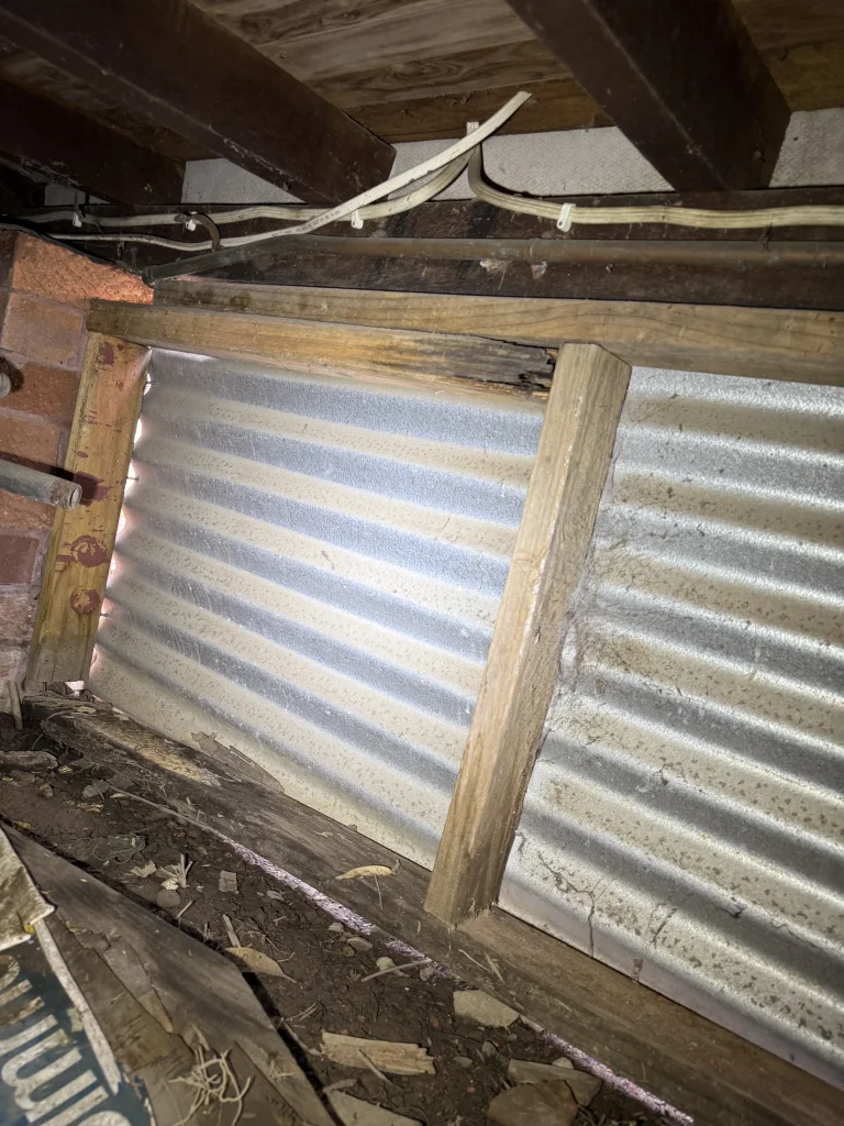 An accessible timber and corrugated construction detail photographed during inspection.