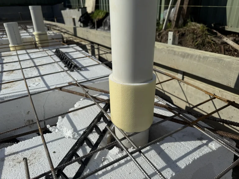 A protected service penetration within slab reinforcement before concrete placement.