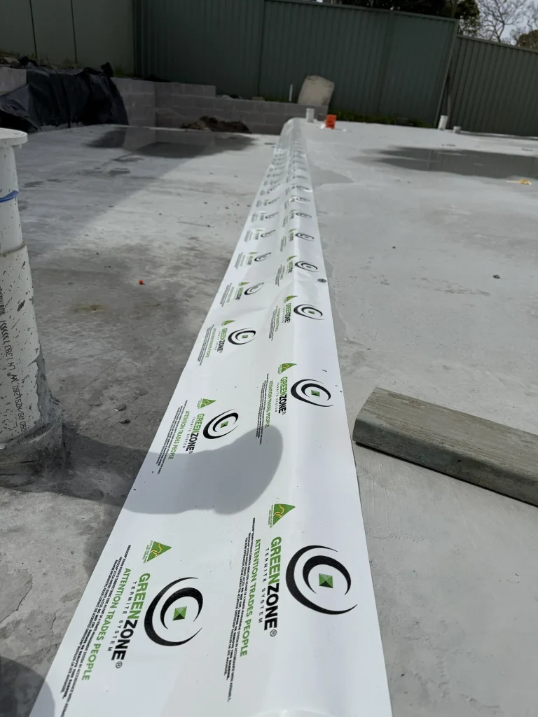 Physical termite-management material installed along a construction junction before completion.