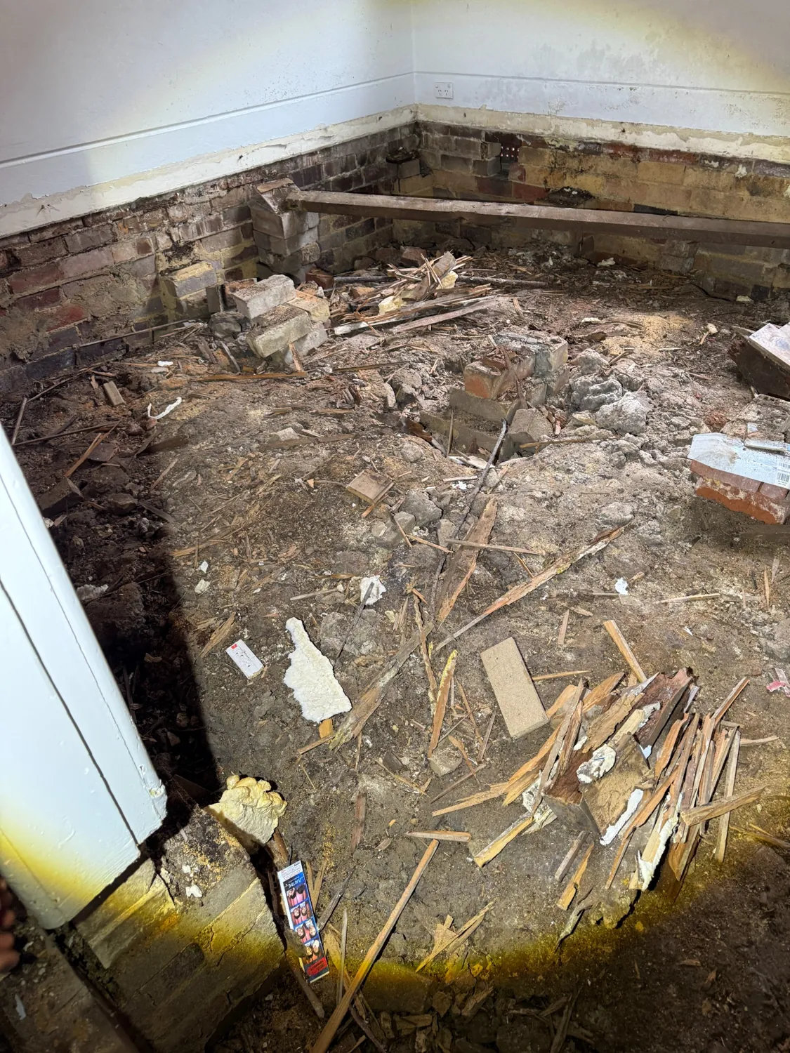 Wide view of exposed room floor and damaged timbers during renovations in Artarmon