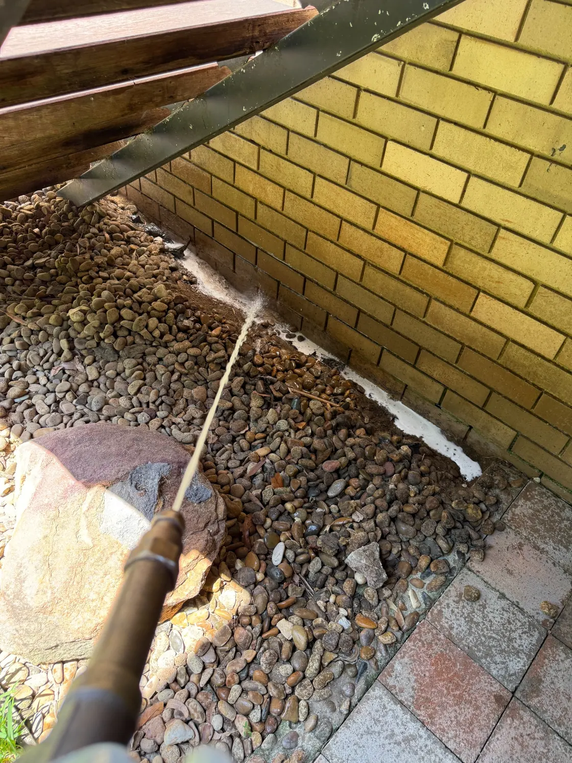 Termidor HE application along brick wall beneath covered outdoor area in Epping