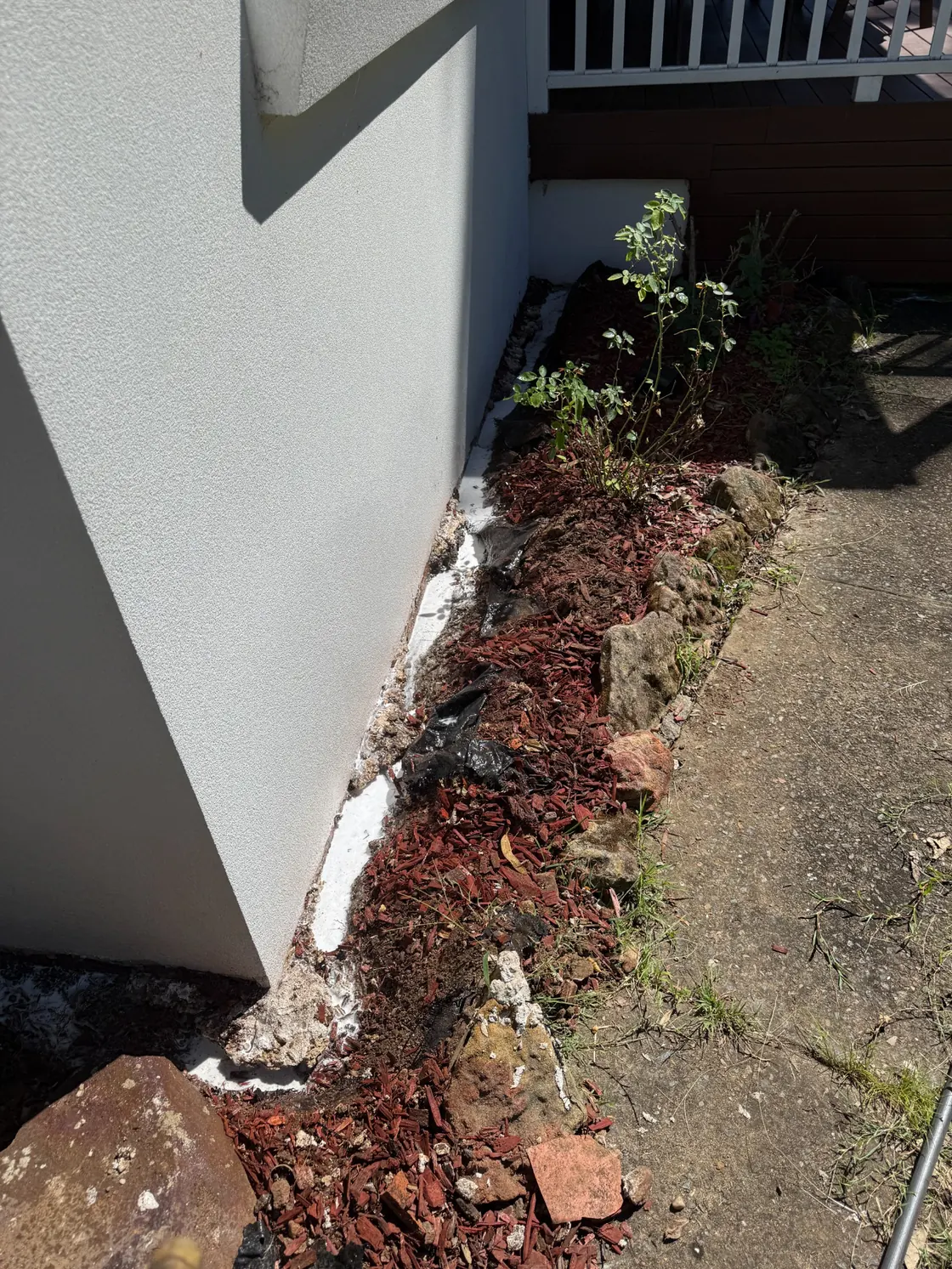 Prepared treatment area at an Epping home beside garden bed and building wall